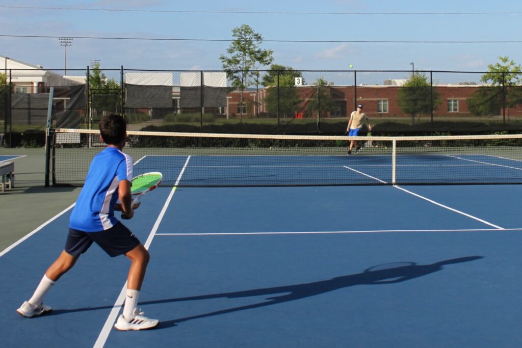 A junior player ready at the baseline during a rally on an ATA court