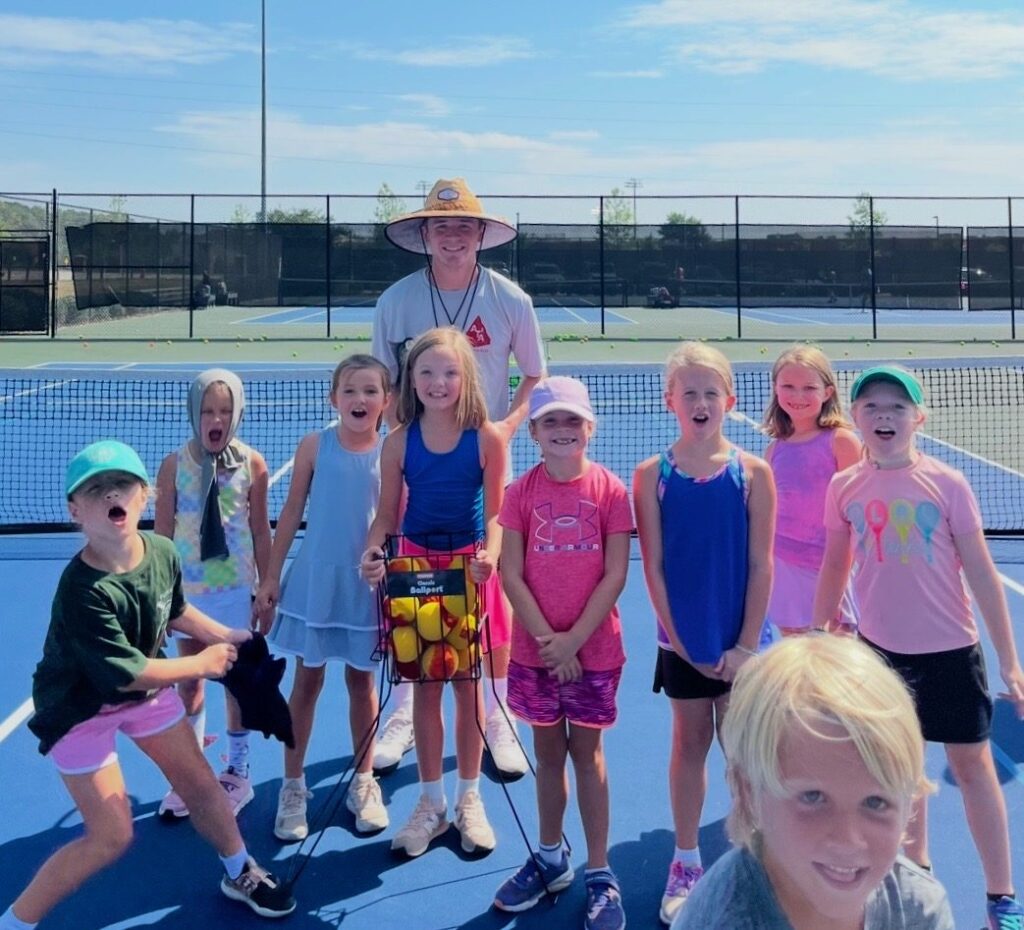 Coach Chandler Brady with a group of excited young players on court