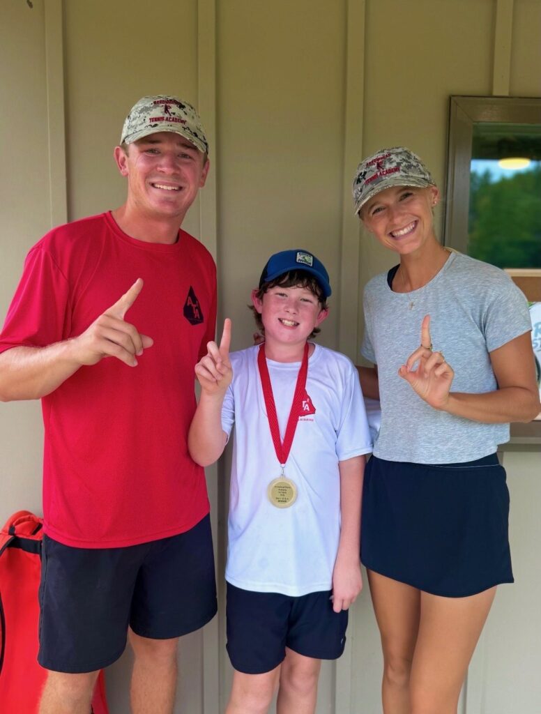 Coaches Chandler and Adelle celebrating with a medal-winning junior